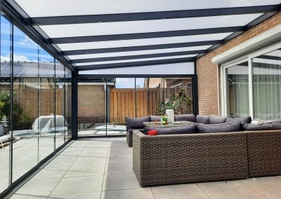 Aluminium veranda met glazen wanden en zithoek